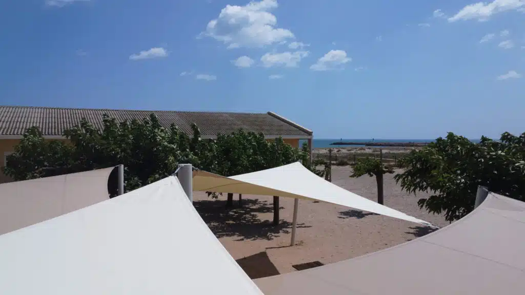 Voiles d’ombrage Soltis 92 poivre et champagne installées au centre de vacances Mer et Soleil à Valras-Plage.