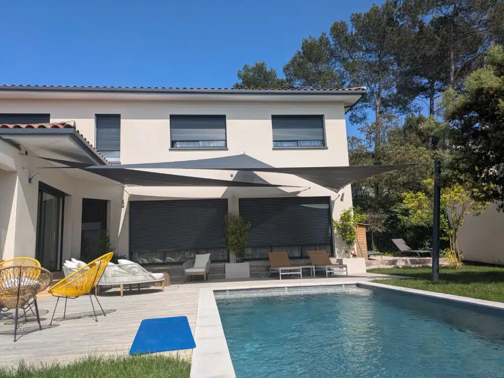 Croisé de voiles d’ombrage Soltis 92 anthracite au-dessus d’une terrasse avec piscine à Montferrier.