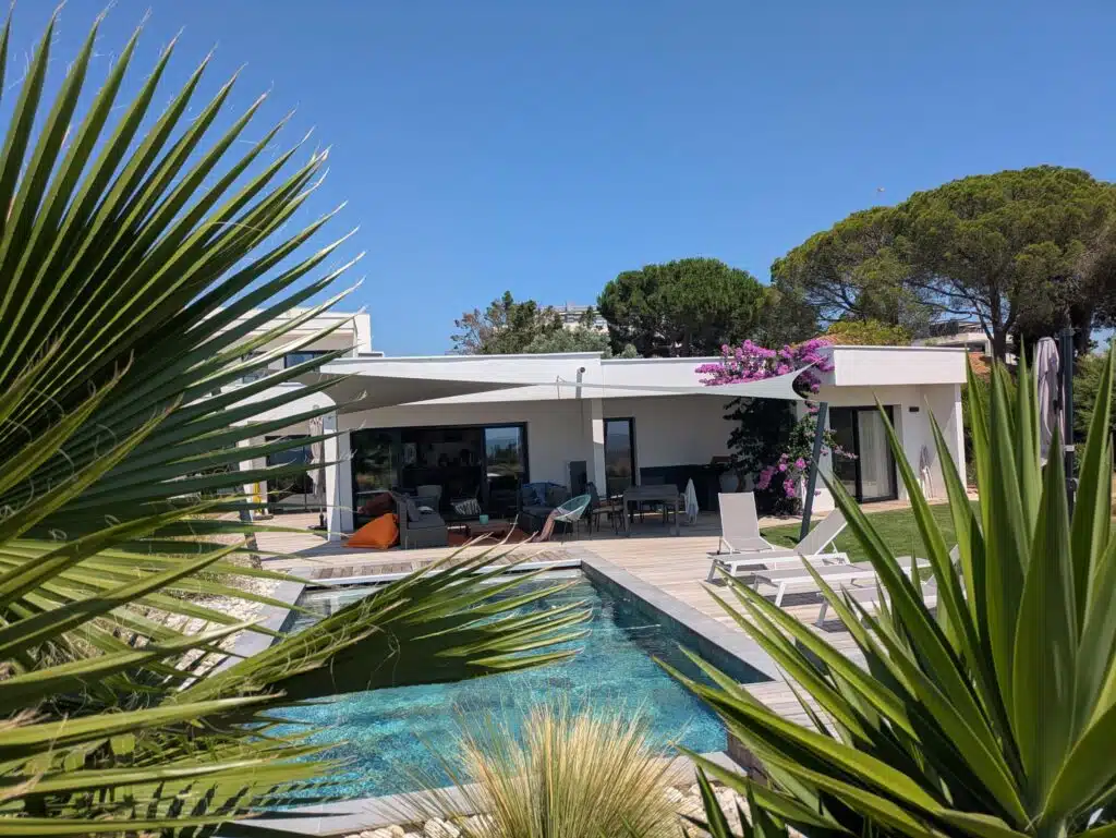 Voile d’ombrage 6 pointes vert de gris Soltis 92 installée sur une maison contemporaine à Mèze.